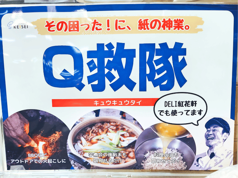 Q救隊の説明のボード。
「その困った！に、紙の神業。Q救隊（キュウキュウタイ）」「DELI紅花軒でも使ってます」と書かれている。
BBQの火おこし、芋煮の後始末、料理油を吸わせている画像がある。